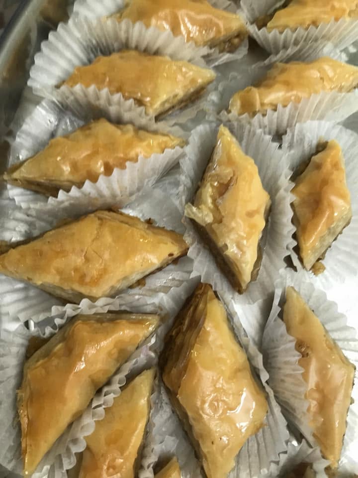 Tray of golden honey glazed baklava diamonds in paper cups