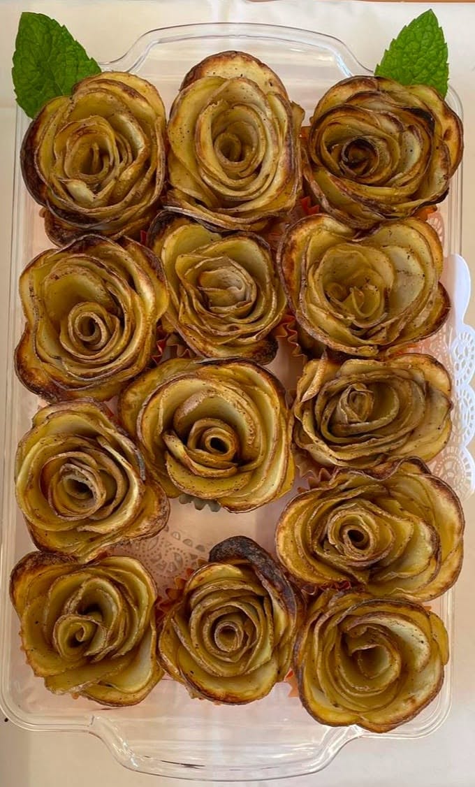 Tray of baked potato roses garnished with fresh mint leaves