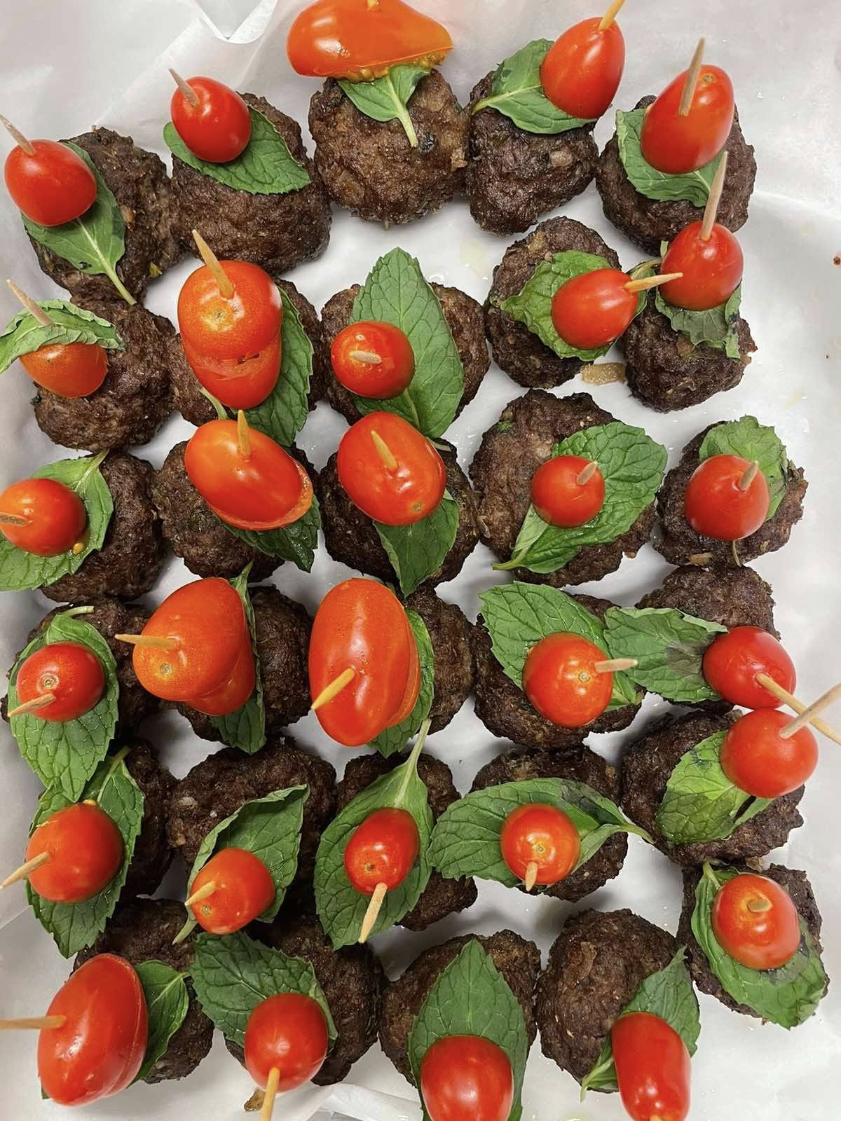 Grilled beef tikka bites skewered with cherry tomatoes and mint leaves