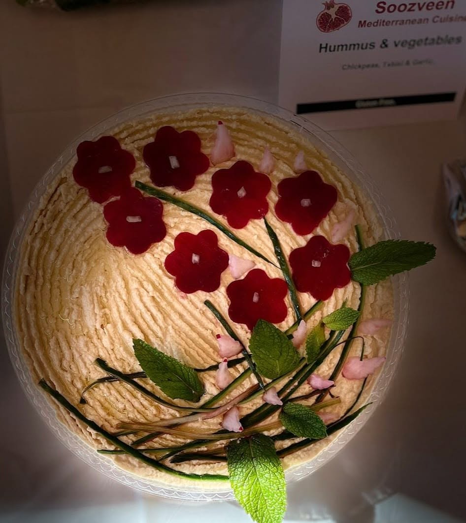 Hummus with tahini and garlic, decorated with radish flowers, chives and mint